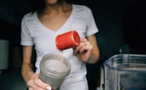 Lady is a making a shake with muscle growth supplement 